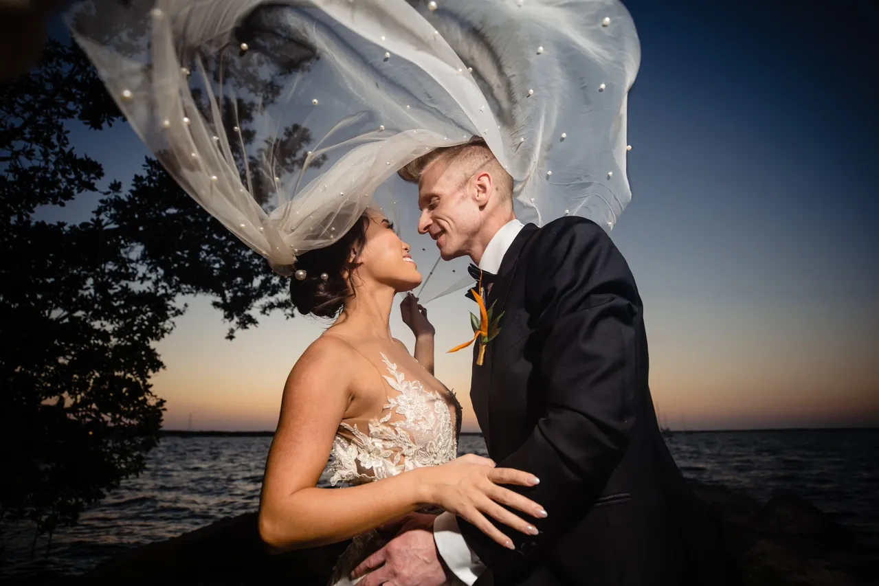Bride and groom at sunset with flying veil